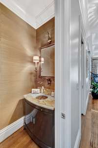 The power room has a Fine Art Girandole chandelier and Cole vanity with LinkaSink mosaic sink.