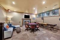 The downstairs game room, in-law suite, has a gas fireplace, tile surround and custom mantle.