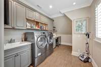 The upstairs laundry room has a lingerie sink with a sewing and ironing area.