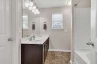 Primary Bathroom features upgraded vanity & light fixtures,  a nice size walk-in closet and comfort height toilet