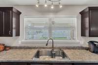 Double window over sink can easily be opened as pass through when entertaining guests on covered patio.