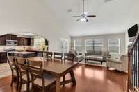 Large Great Room with vaulted ceiling/light fan fixture and engineered wood floors