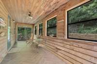 quiet sunroom off back of house has tiled floor with all new windows and Anderson doors on each end
