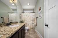 The main floor bathroom conveniently located to Bedroom 2 and the kitchen/laundry areas.
