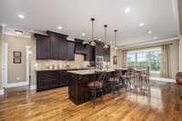 Another look at this kitchen will reveal a breakfast nook with triple windows overlooking the backyard, recessed lighting, granite countertops and tile backsplash.