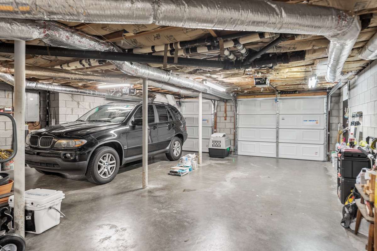 Spacious basement garage with ample parking, concrete floors, and a dedicated workshop area—ideal for projects, storage, and secure vehicle space.