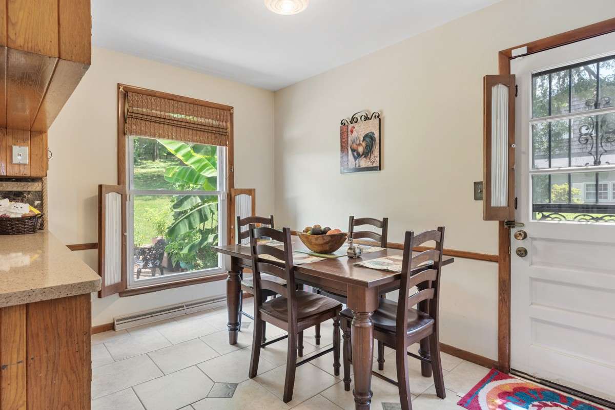 Bright eat-in kitchen area with large windows offering views of the backyard—perfect for casual meals or morning coffee in a cheerful breakfast nook.