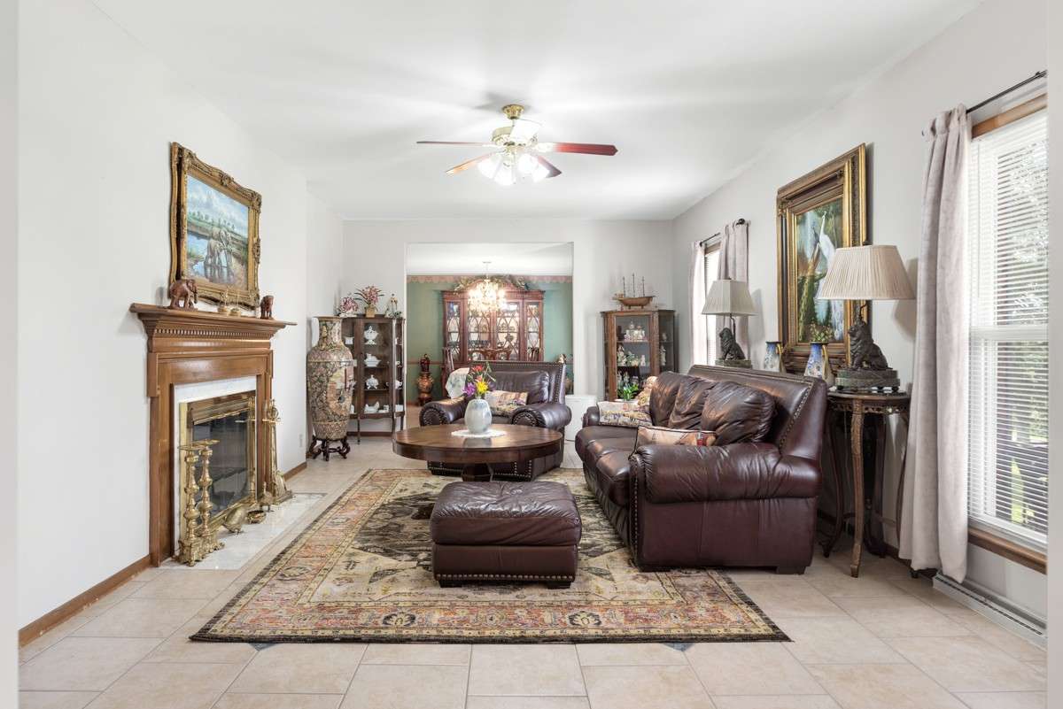 Elegant formal living room with a wood-burning fireplace flows into the formal dining room—perfect for entertaining and filled with natural light.