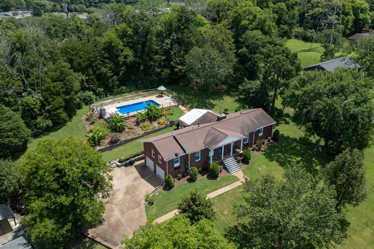Beautiful brick home on a spacious, private lot with lush landscaping and an inviting backyard pool—perfect for relaxing or entertaining.