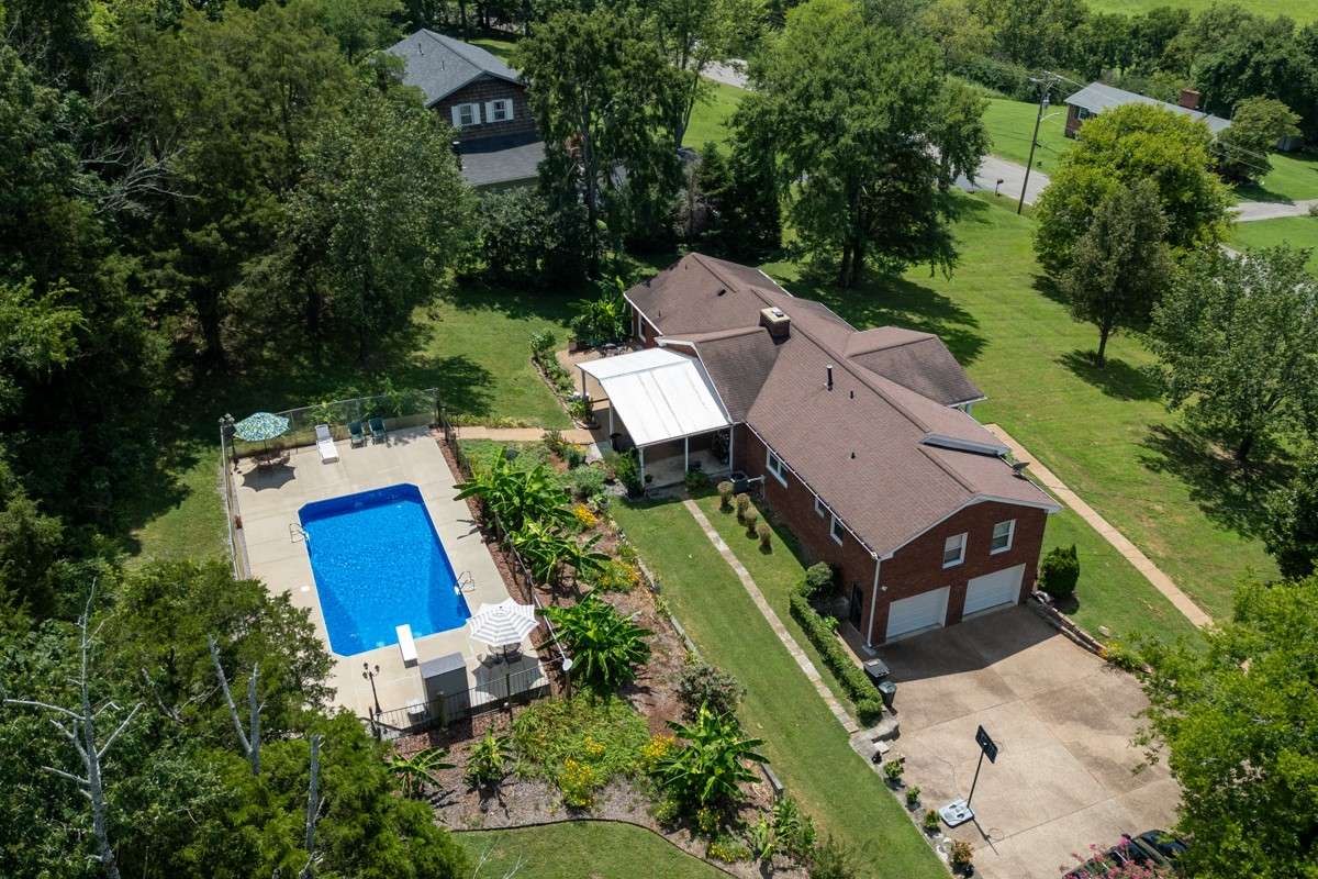 Enjoy a 33 x 16 inground pool with a diving board, surrounded by privacy fencing and lush landscaping—perfect for summer fun and relaxation.