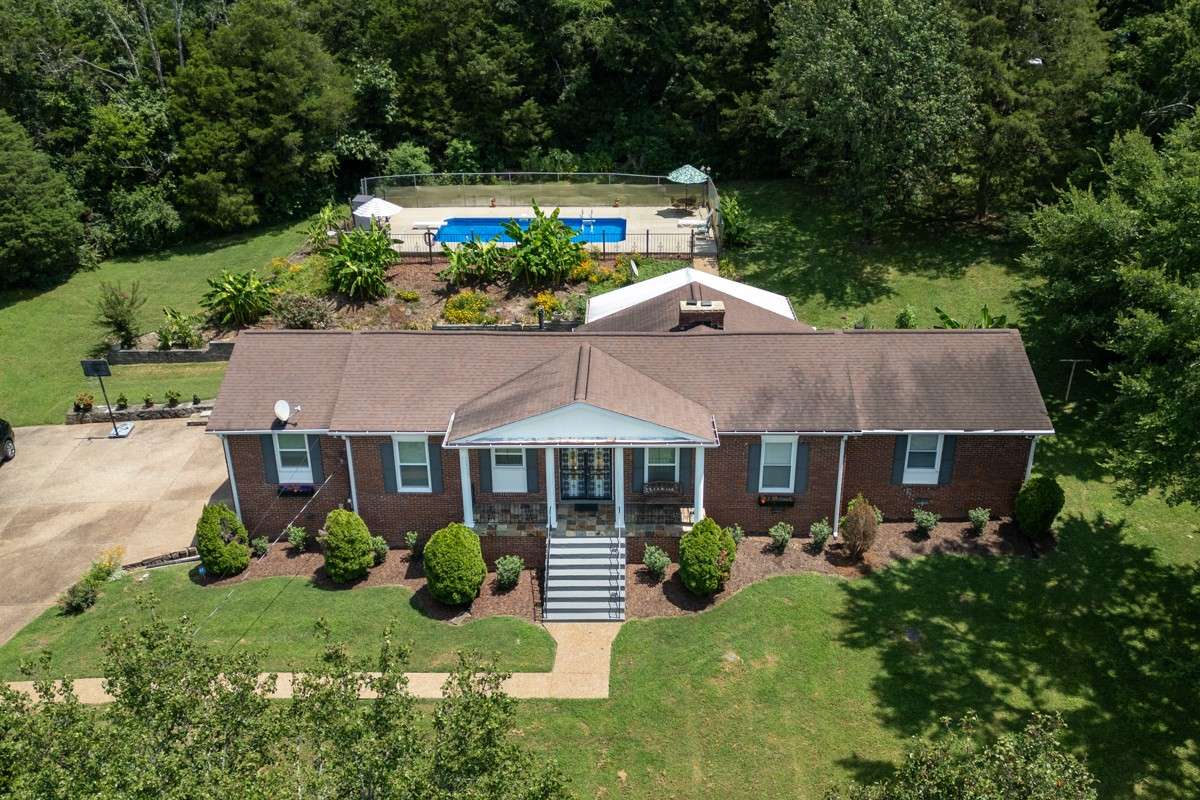 Beautiful brick home on a spacious, private lot with lush landscaping and an inviting backyard pool—perfect for relaxing or entertaining.