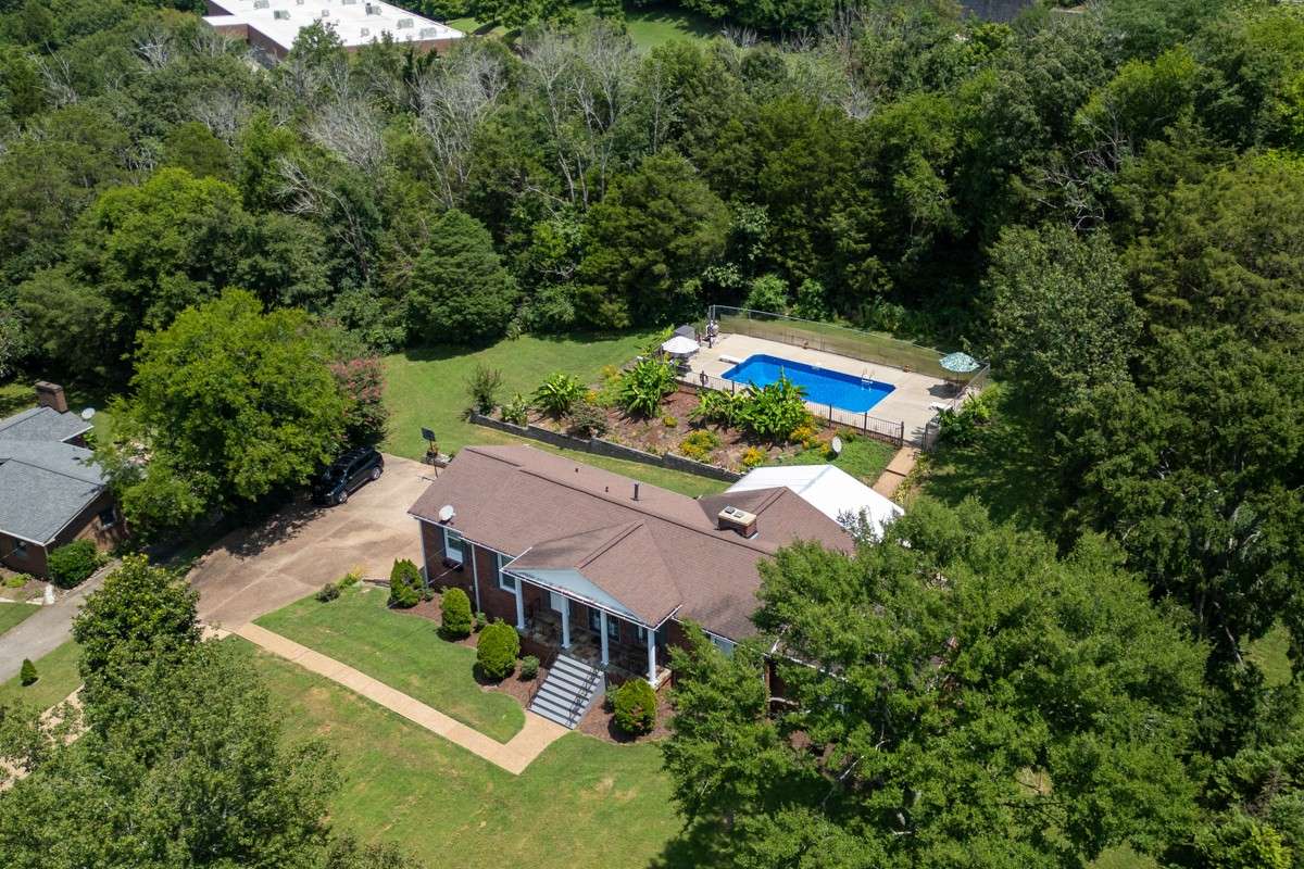 Beautiful brick home on a spacious, private lot with lush landscaping and an inviting backyard pool—perfect for relaxing or entertaining.