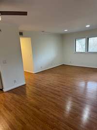 Recessed lighting in the livingroom, which opens to a balcony overlooking lush greenery.