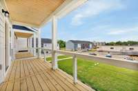 Large covered balcony that will overlook green spaces with fire pits.