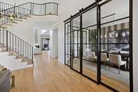 The glass wall enclosed dining room sets an elegant, yet warm vibe for the home