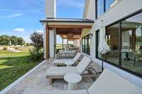 Relax on the lovely travertine patio overlooking the backyard view