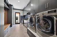 Located on the main floor, the laundry room is a large space boasting tons of storage. The door exists to the guest house and additional garages