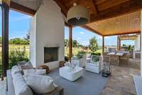 The outdoor covered patio with wood burning fireplace