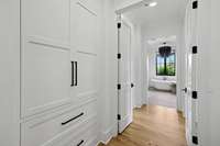 Entering the Primary suite, the hallway has extensive storage options