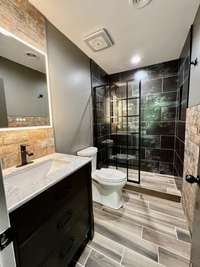 Primary Bathroom with tile flooring; Walk in tile shower; Vanity with marble top and backsplash; Modern Primary Bath