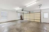 Large two car garage with a pedestrian door.  Not shown in the picture is an upgraded 80 gallon hot water heater, gas.