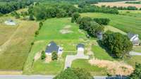 All the patches of dirt will green up in No time! 5.29 acres mostly flat, with natural woods, and a pond at the rear of the property.
