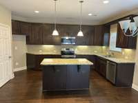 Kitchen with counter lights and island pantry on left