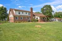 Back of home features a large covered patio w/ dedicated fire-pit circle & uninterrupted views of acreage.