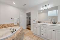 The primary bath is spacious with a soaking tub, double vanity and shower