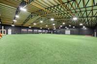 100'x80' building is has two industrial fans with smart thermostats for cooling, two 10' Roll-up doors, 2 Reznor commercial gas heaters. 20' center height. The concrete under turf is monolithic slab and post/footer. LED lights, security and wi-fi!