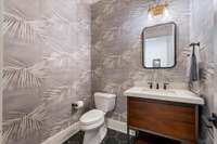 Half bath between kitchen and office with designer wall paper.
