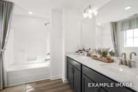 The owner's bathroom features dual sinks & lots of cabinetry for storage.
