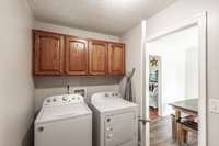 Large Utility Room off the kitchen with custom cabinetry for storage.
