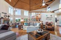 Expansive two story great room with custom hexagon tongue and groove wood ceiling and floor to ceiling windows.