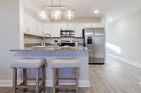 Kitchen includes breakfast bar, plenty of cabinets, & pantry!