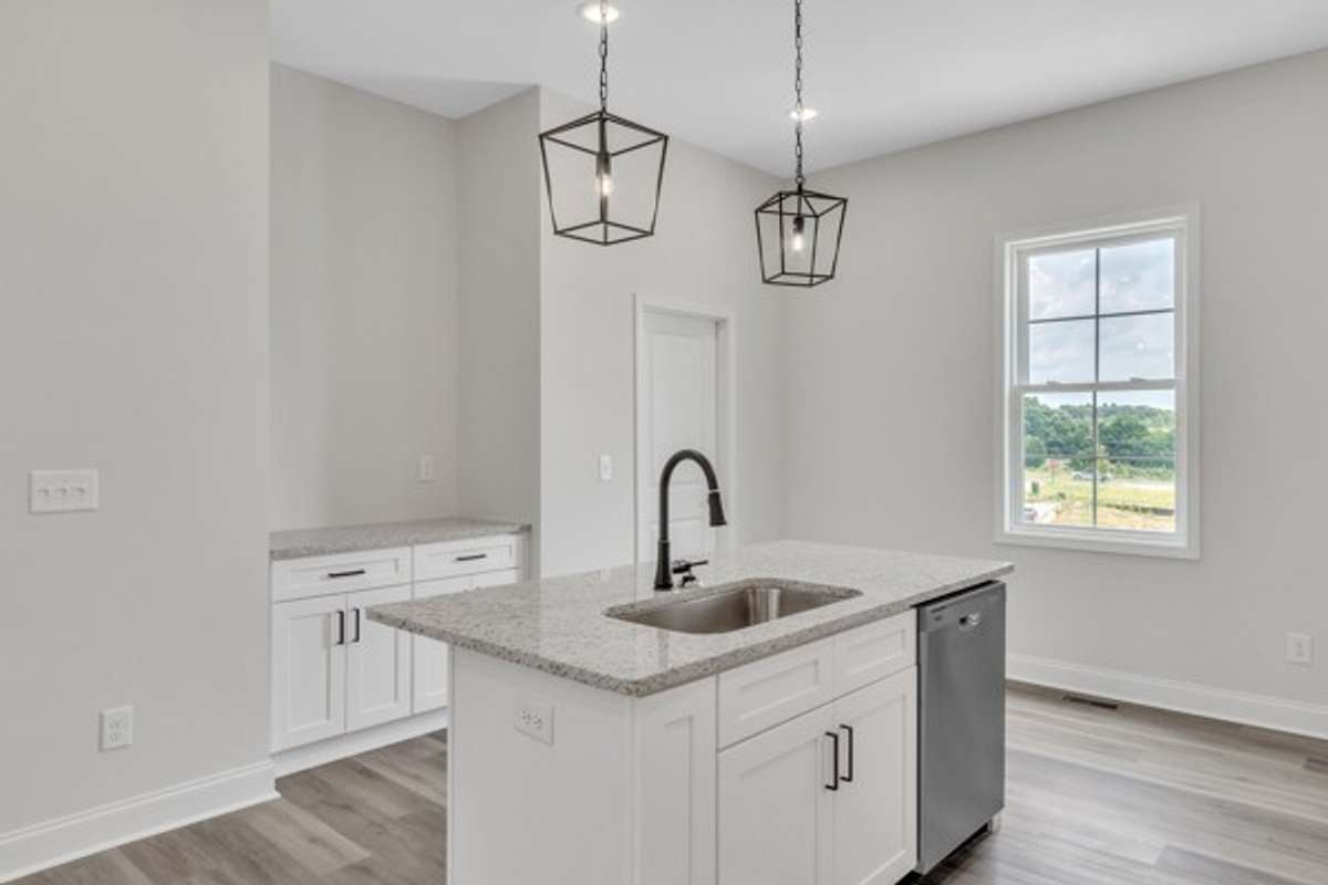 Notice the additional serving area across from large kitchen island and the door leads to a convenient pantry for additional storage.