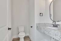 This half bath is tucked away from the living space across from the stairs.