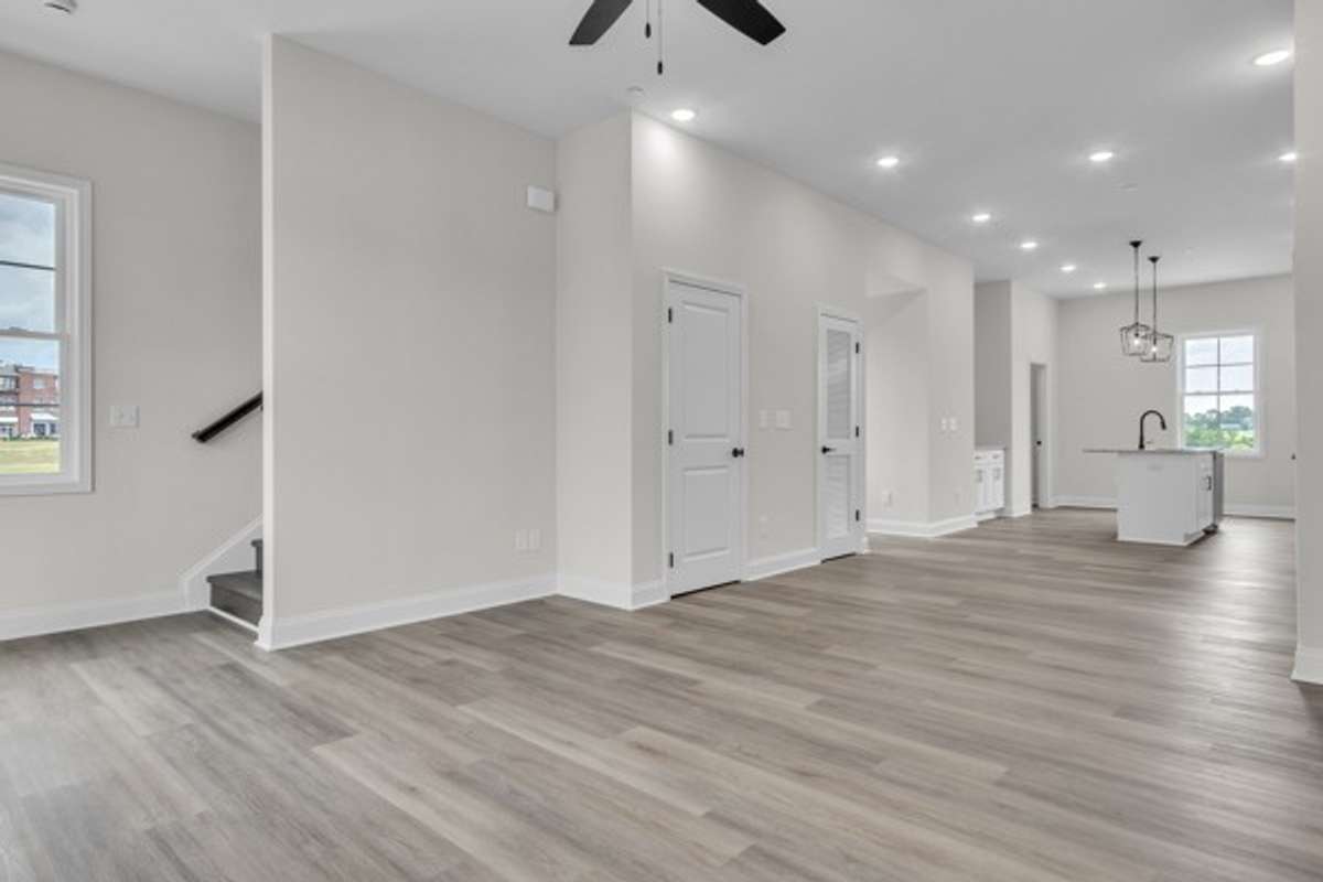 You will love the plentiful lighting and modern ceiling fans. This shot is back toward the dining and kitchen space. The stairs head up to the final 2 bedrooms including the primary bedroom and 2nd guest bedroom.