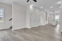 You will love the plentiful lighting and modern ceiling fans. This shot is back toward the dining and kitchen space. The stairs head up to the final 2 bedrooms including the primary bedroom and 2nd guest bedroom.