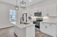 This kitchen is so bright and friendly with multiple light sources including the pendants, recessed lighting, under cabinet lighting and large window to let natural light stream in.