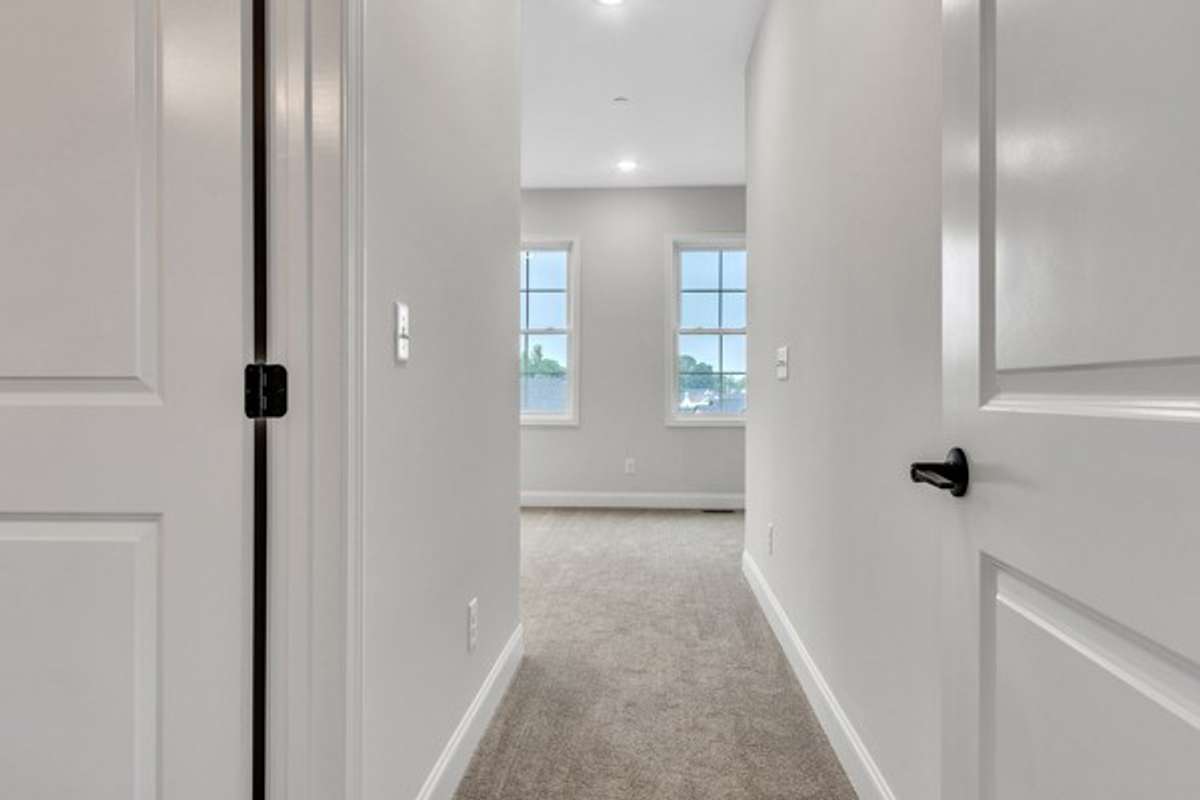 Entry into the primary suite area with the primary bath to the left.