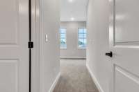 Entry into the primary suite area with the primary bath to the left.