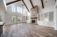 Soaring vaulted ceilings, exposed beams, and floor-to-ceiling windows highlight the great room—featuring a stone fireplace, built-ins, and designer paint throughout.