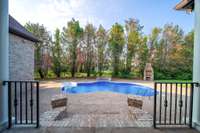 Enjoy a sparkling pool, outdoor fireplace, and spacious patio surrounded by privacy trees—ideal for entertaining or relaxing in your own backyard oasis.