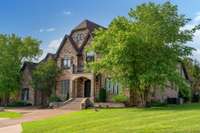 With the timeless exterior, circular drive, porte-cochère garage entry, and mature landscaping. This home blends timeless curb appeal with luxury features in a serene, sought after neighborhood.