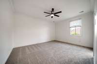Bedroom #2 upstairs features plush new carpet, new ceiling fan, brigh window and crown molding.