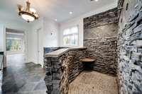 Step into your spa-style walk-in shower with custom stone work and fresh grout. Large shower head and spray handle for easy cleaning and total body spray settings.