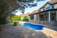 Private, tree-lined, and fully fenced backyard oasis with a brand-new pool liner and pumps, outdoor fireplace, built-in grill, and spacious patio—perfect for relaxing or entertaining.