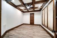 Main-level office with coffered ceiling, rich wood trim, custom blinds, and new luxury vinyl plank flooring—freshly painted in designer colors throughout.