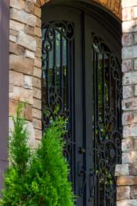 Stately wrought-iron double doors offer both security and artistry, setting a grand tone for the luxury that lies within.